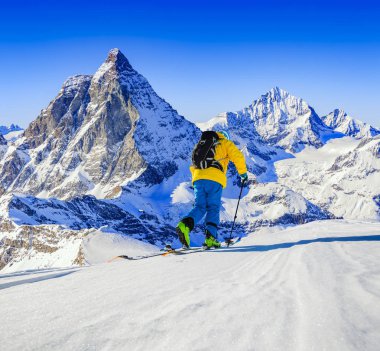 Taze toz karda kayak adam. Karlı dağların tepesinde kış sezonu, dağlar ve Tur kayağı backcountry aletleri ile arka planda Matterhorn, İsviçre Alpleri'nde Zermatt güneşli gün Kayak.