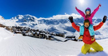 Mutlu bir aile dağlarda kış tatilinin tadını çıkarıyor Val Thorens, 3 vadi, Fransa. Yüksek dağlarda kar ve güneşle oynamak. Kış tatili.