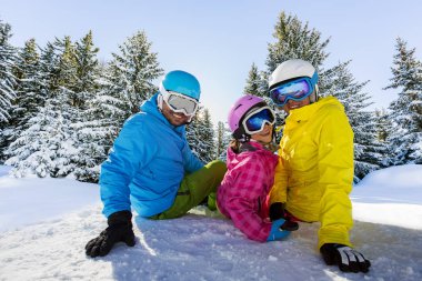 Mutlu bir aile dağlarda kış tatil zevk. Kar ile yüksek dağlar güneşte oynarken. Kış tatili.