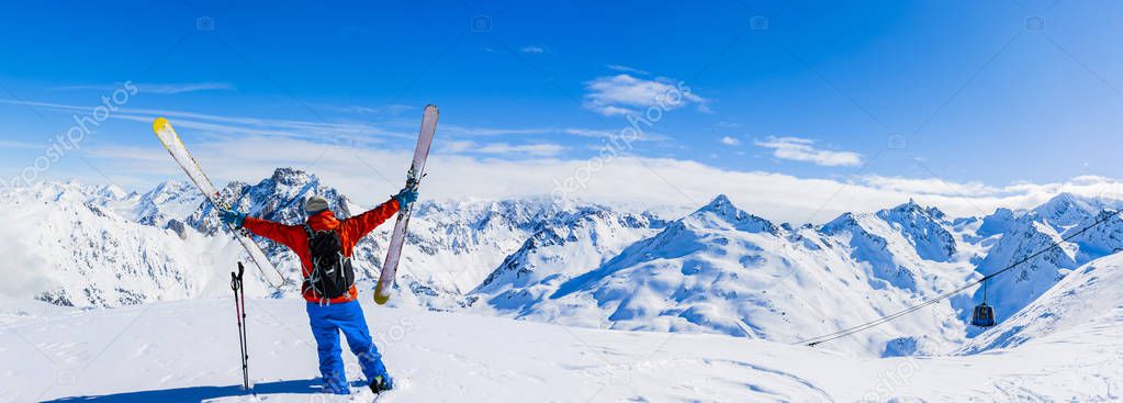 Ski in winter season, mountains and ski touring equipments on the top in sunny day in France, Alps above the clouds