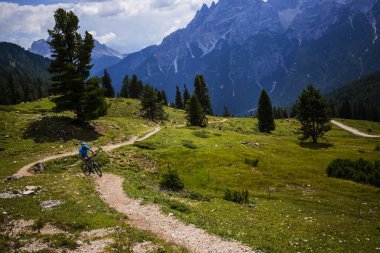 Rocky Dağları arka plan üzerinde çarpıcı turist Cortina d'Ampezzo, Bisiklete binme. MTB enduro akışı iz kişini. South Tyrol İtalya il, Dolomites.