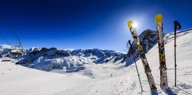 Ski in winter season, mountains and ski touring equipments on the top in sunny day in France, Alps above the clouds clipart