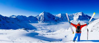 Dağcı backcountry Kayak kolları açık olan Dağları'nın karlı bir sırt boyunca. Arka plan mavi gökyüzü ve parlak güneş ve Güney Tirol, İtalya için Ortler. Macera kış aşırı spor. 