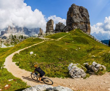 Cinque Torri ve Tofana arka planda çarpıcı turist kadın Cortina d'Ampezzo, Bisiklete binme. MTB enduro akışı iz kişini. South Tyrol İtalya il, Dolomites.