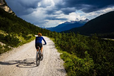 Rocky Dağları arka plan üzerinde çarpıcı turist Cortina d'Ampezzo, Bisiklete binme. Kadın MTB enduro akışı iz sürme. South Tyrol İtalya il, Dolomites.