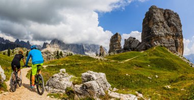 Çift Cortina d'Ampezzo, Cinque Torri ve Tofana arka planda çarpıcı Bisiklete binme. Kadın ve adam Mtb iz sürme. South Tyrol İtalya il, Dolomites.