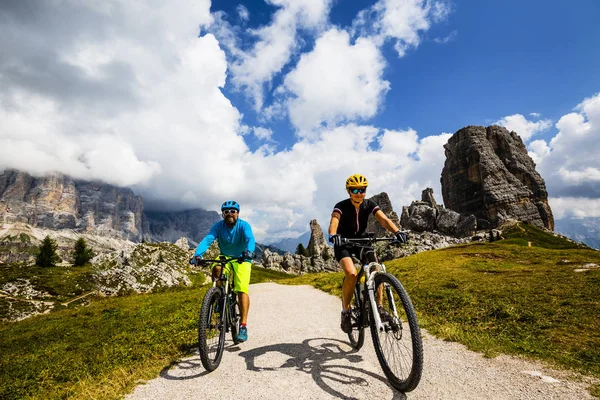 カップルは バック グラウンドで美しいチンクエ トーリとトファーナ コルティーナ ダンペッツォでのサイクリングします 女と男の Mtb トレイルに乗って イタリア南チロル州 — ストック写真