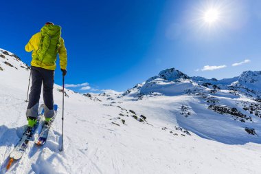 Skitouring with amazing view of swiss famous mountains in beautiful winter powder snow of Alps.  clipart