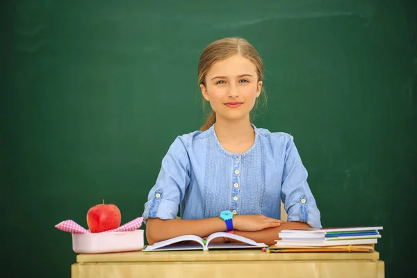 回学校去美丽的女孩坐在教室里靠黑板 孩子在学校与书和配件 具有复制空间的教育理念 — 图库照片
