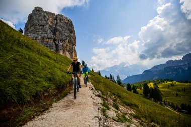 Çift Cortina d'Ampezzo, Cinque Torri ve Tofana arka planda çarpıcı Bisiklete binme. Kadın ve adam Mtb iz sürme. South Tyrol İtalya il, Dolomites.