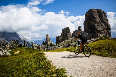 Çift Cortina d'Ampezzo, Cinque Torri ve Tofana arka planda çarpıcı Bisiklete binme. Kadın ve adam Mtb iz sürme. South Tyrol İtalya il, Dolomites.
