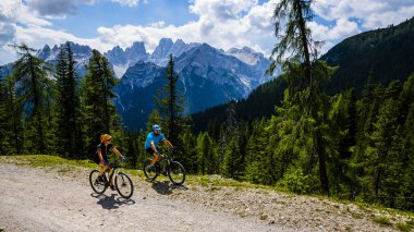 Rocky Dağları arka plan üzerinde çarpıcı turist Cortina d'Ampezzo, Bisiklete binme. Aile binme Mtb enduro akışı iz. South Tyrol İtalya il, Dolomites.