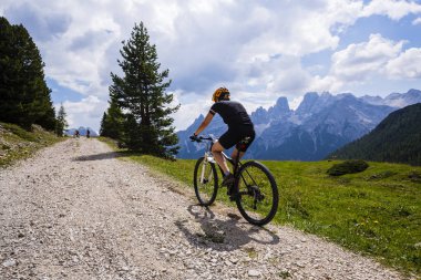 Rocky Dağları arka plan üzerinde çarpıcı turist Cortina d'Ampezzo, Bisiklete binme. Kadın MTB enduro akışı iz sürme. South Tyrol İtalya il, Dolomites.