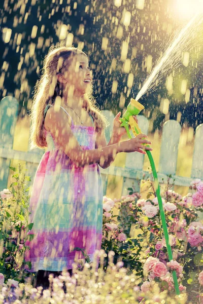 缤纷夏日 可爱女孩有好玩的浇水在花园里的花 — 图库照片
