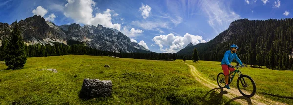 Tourist cycling in Cortina d'Ampezzo, stunning rocky mountains o — Stock Photo, Image