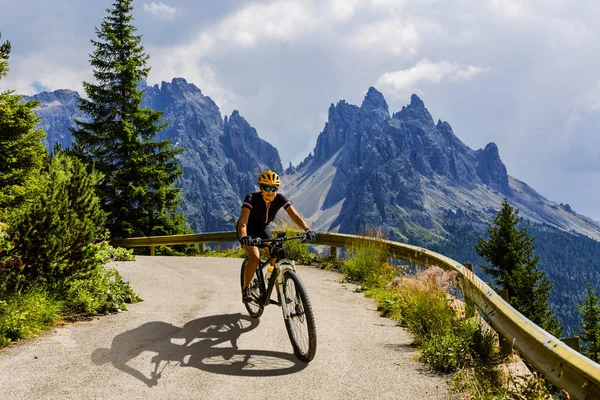 Turistická cyklistika v Cortina d'Ampezzo, ohromující skalnaté hory o — Stock fotografie