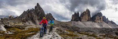 Bisiklete binme kadın ve motosiklet Dolomites dağlarda kişini ve