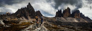 Bisiklete binme kadın ve motosiklet Dolomites dağlarda kişini ve