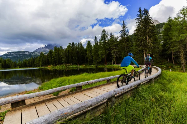 Cycling woman and man riding on bikes in Dolomites mountains and — Stock Photo, Image