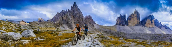 Ciclismo mulher e homem andando de bicicleta em Dolomites montanhas e — Fotografia de Stock