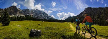 Bisiklete binme kadın ve motosiklet Dolomites dağlarda kişini ve