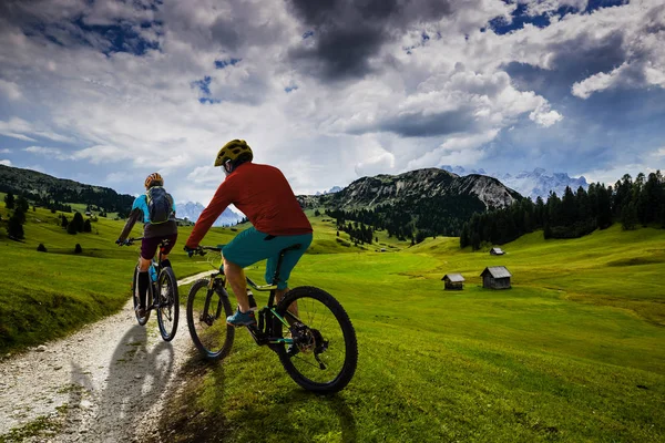 Ciclismo mujer y hombre a caballo en bicicletas en las montañas Dolomitas y —  Fotos de Stock