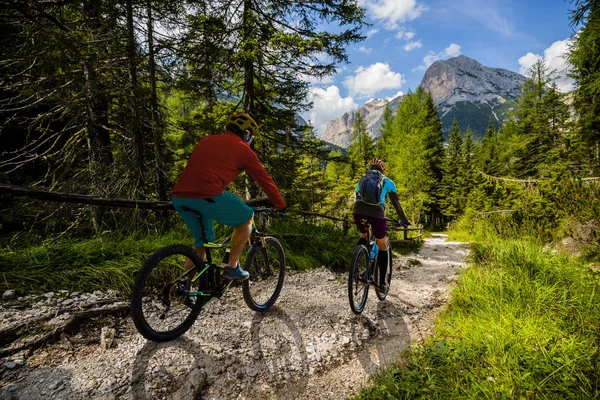 Ciclismo mujer y hombre a caballo en bicicletas en las montañas Dolomitas y — Foto de Stock