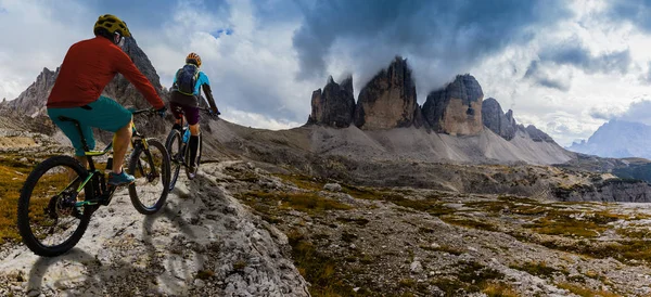 Ciclismo mujer y hombre a caballo en bicicletas en las montañas Dolomitas y — Foto de Stock