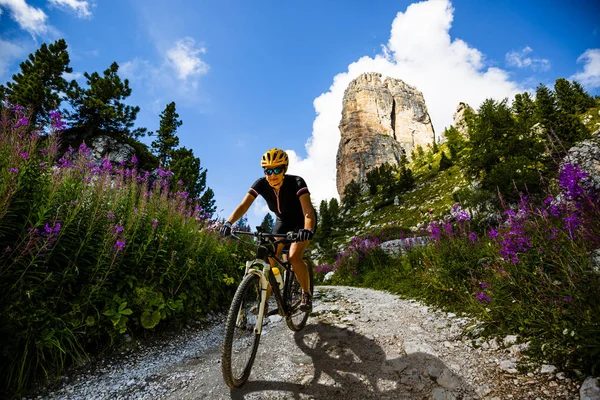 Cycling woman and man riding on bikes in Dolomites mountains lan