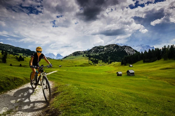 Tourist cycling in Cortina d'Ampezzo, stunning rocky mountains o — Stock Photo, Image