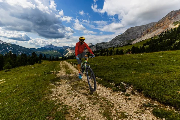 Tourist cycling in Cortina d'Ampezzo, stunning rocky mountains o — Stock Photo, Image