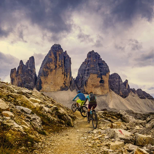Cykling kvinna och man rider på cyklar i Dolomiterna och — Stockfoto