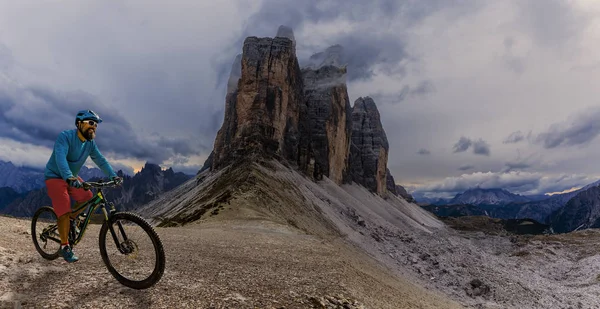 Cycling woman and man riding on bikes in Dolomites mountains and
