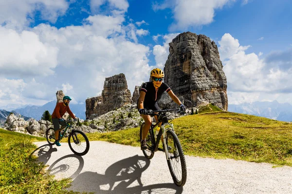 Ciclismo mulher e homem andando de bicicleta em Dolomites montanhas lan — Fotografia de Stock