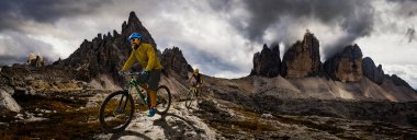Bisiklete binme kadın ve motosiklet Dolomites dağlarda kişini ve
