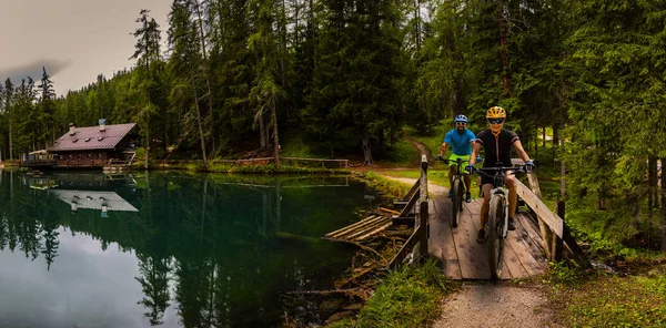 Cycling woman and man riding on bikes in Dolomites mountains and — Stock Photo, Image