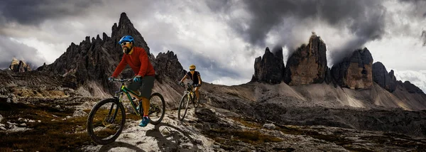 Ciclismo mulher e homem andando de bicicleta em Dolomites montanhas e — Fotografia de Stock