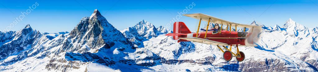 Child girl pilot aviator in airplane flying over winter mountain