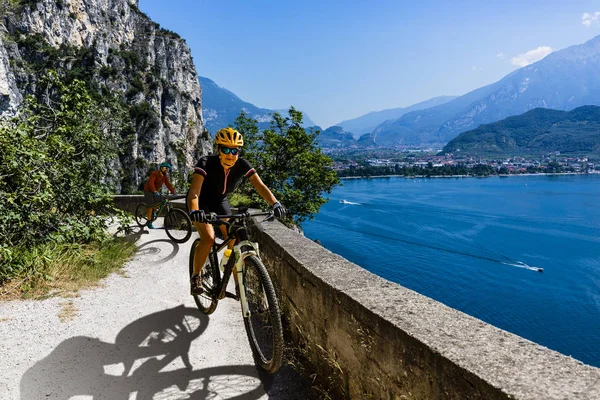 Ciclismo mulher e homem andando de bicicleta ao nascer do sol montanhas e G — Fotografia de Stock