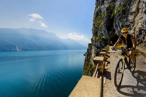 Garda Gölü üzerinde gün doğumunda dağ bisikleti kadın — Stok fotoğraf