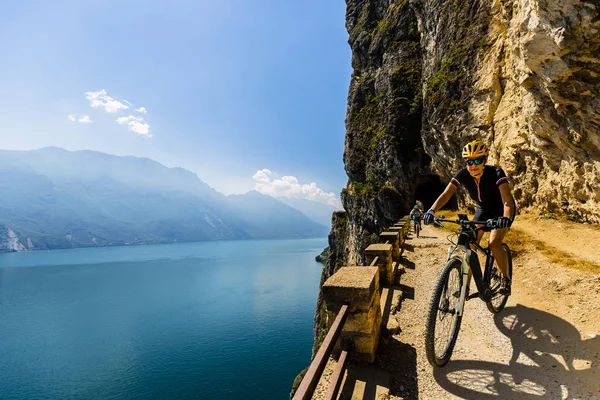 Ciclismo mulher e homem andando de bicicleta ao nascer do sol montanhas — Fotografia de Stock