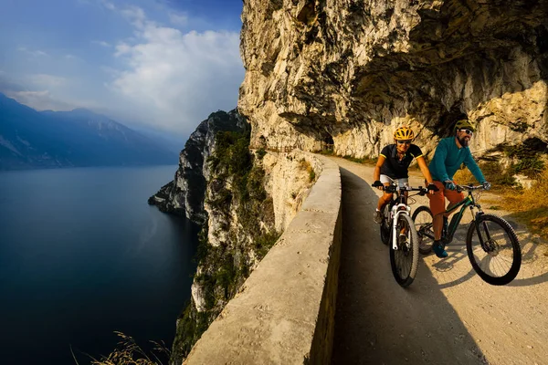 Cycling woman and man riding on bikes at sunrise mountains and G — Stock Photo, Image