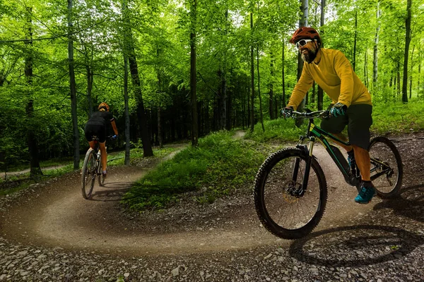 Radfahrende Frauen und Männer auf Fahrrädern im Sonnenuntergang Bergwald — Stockfoto