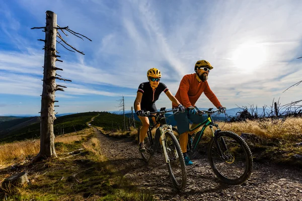 Ciclismo mujer y hombres montando en bicicletas en el atardecer montañas bosque —  Fotos de Stock