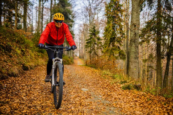 Cycling woman riding on bike in autumn mountains forest landscap — Stock Photo, Image