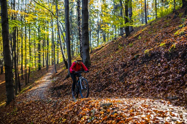 Cycling woman riding on bike in autumn mountains forest landscap — Stock Photo, Image