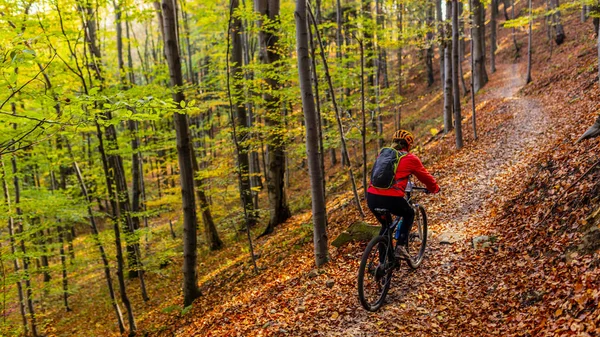 Cycling woman riding on bike in autumn mountains forest landscap — Stock Photo, Image