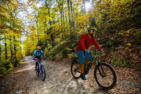 Ciclismo, casal de ciclistas de montanha em trilha de bicicleta na floresta de outono . — Fotografia de Stock