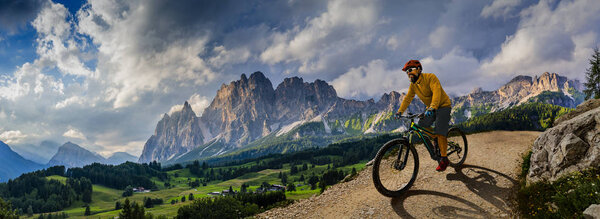 Man cycling on electric bike, rides mountain trail. Man riding o