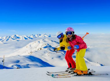 Dağlarda kış tatillerinin tadını çıkaran mutlu aile, Val Thorens